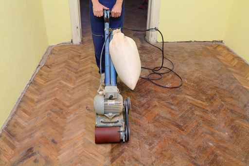 Worker polishing parquet floor with grinding machine Parkett Kirion - Renovierung